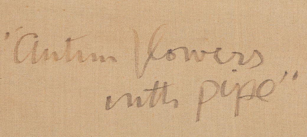 Close-up of a two-line handwritten inscription in dark pencil on tan canvas; the visible words read “Autumn flowers” above “with pipe.”